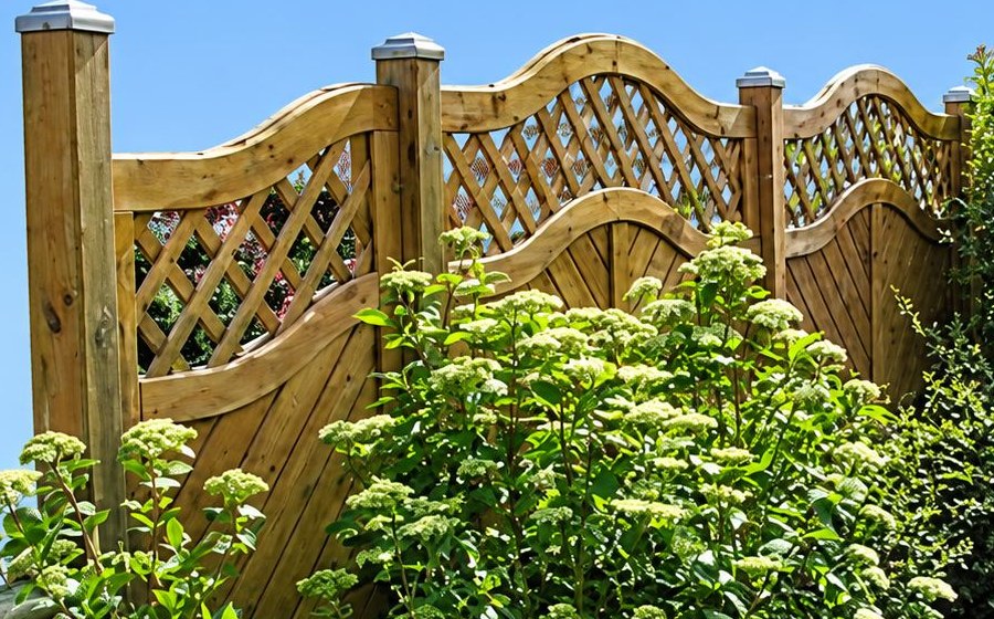 Clôture en bois ajourée à lattes croisées, posts à embout métal